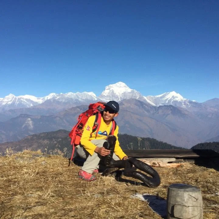 Urja Tamang with a hiking backpack in a mountain landscape