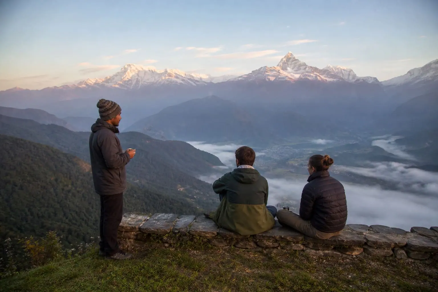 Travelers and a local guide watching sunrise over the Annapurna range near Pokhara