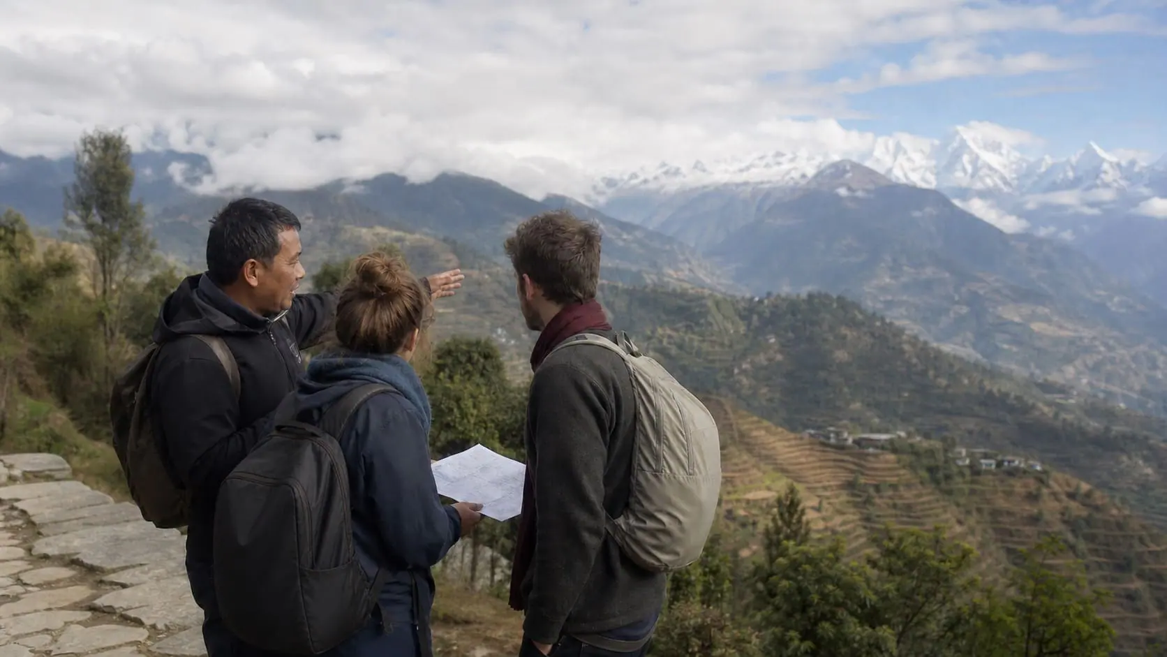 Local guide discussing changing Nepal mountain weather with two travelers